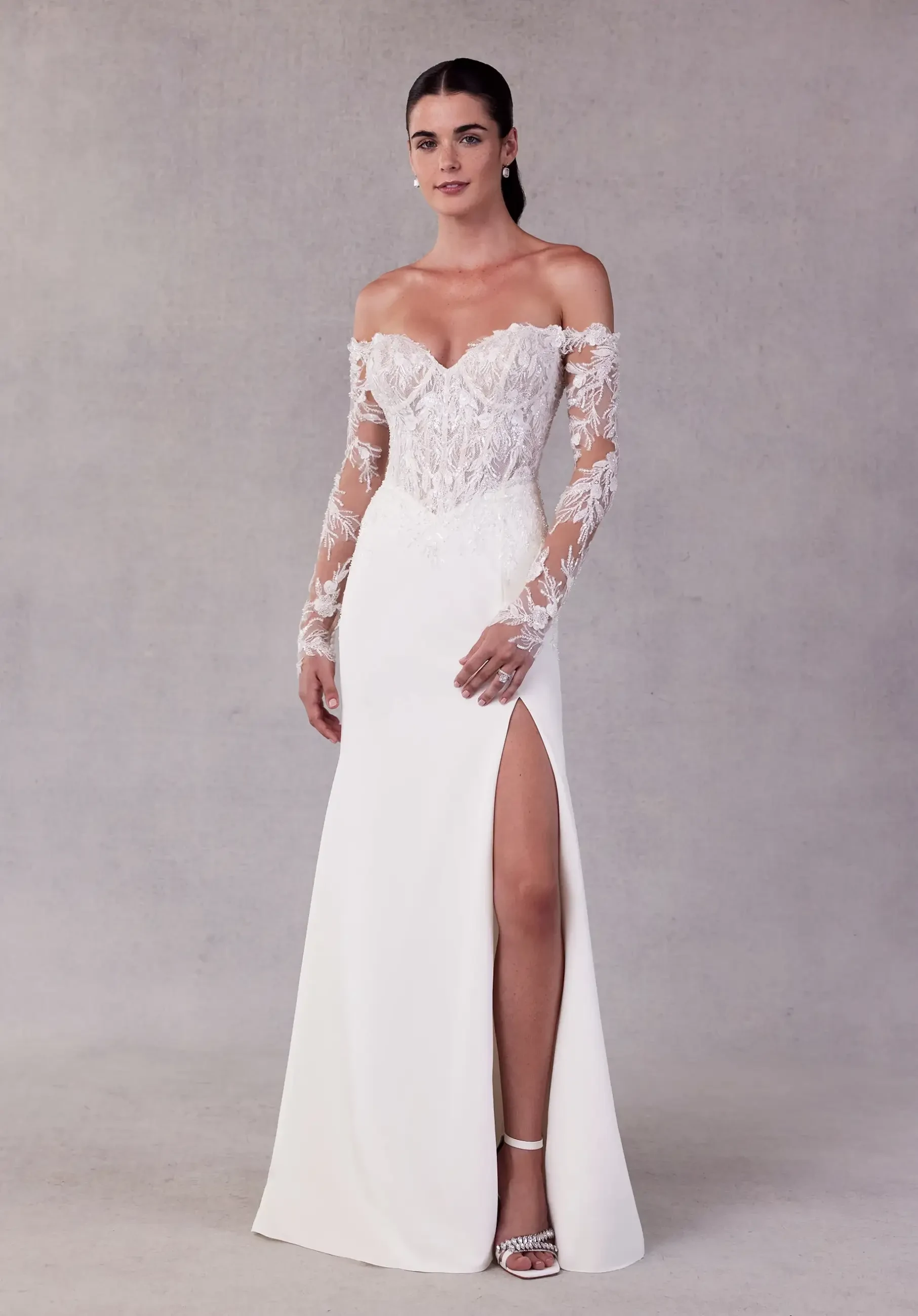 model is wearing a fit and flare long sleeve wedding dress