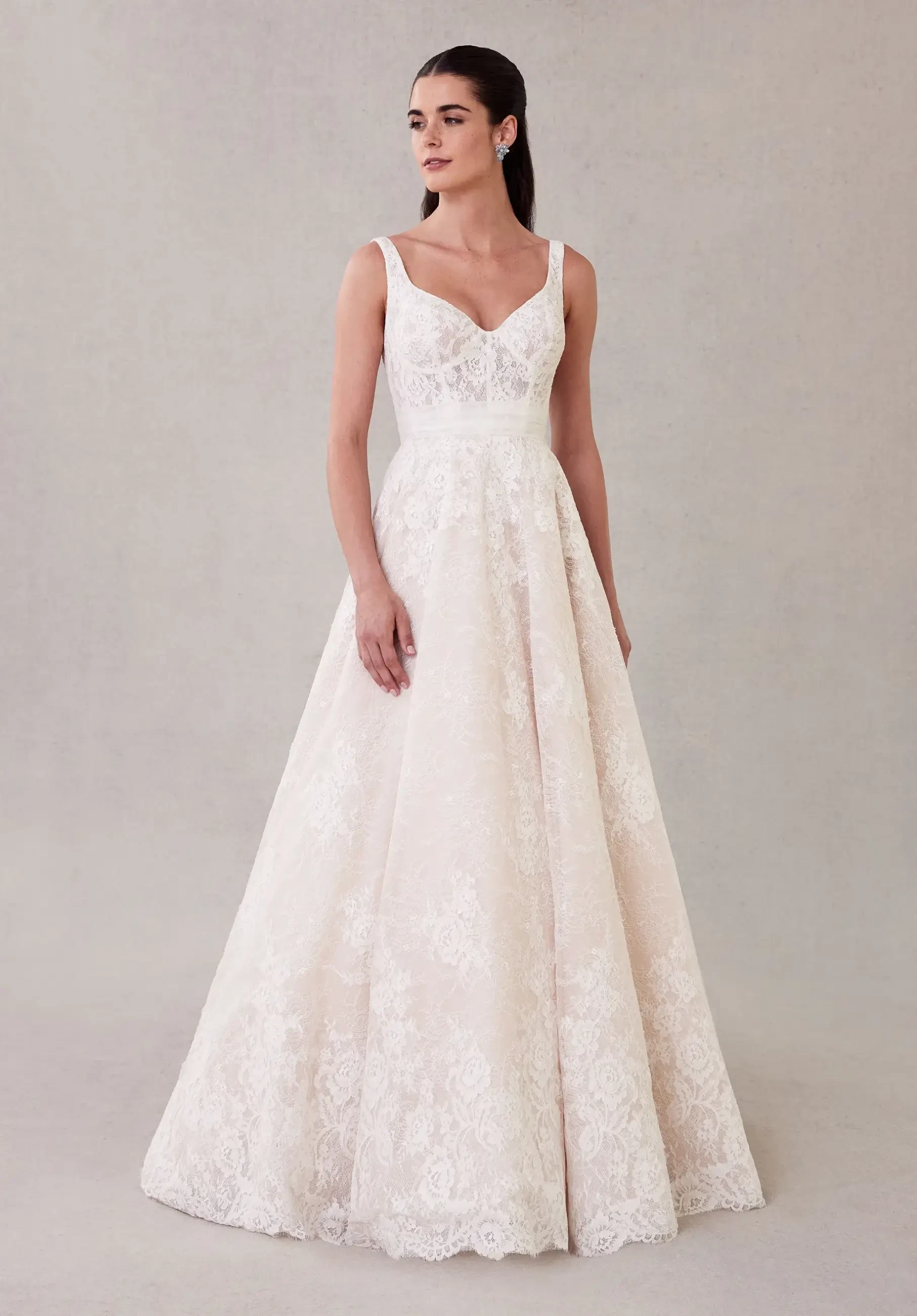 model is wearing a sleeveless a-line lace bridal gown