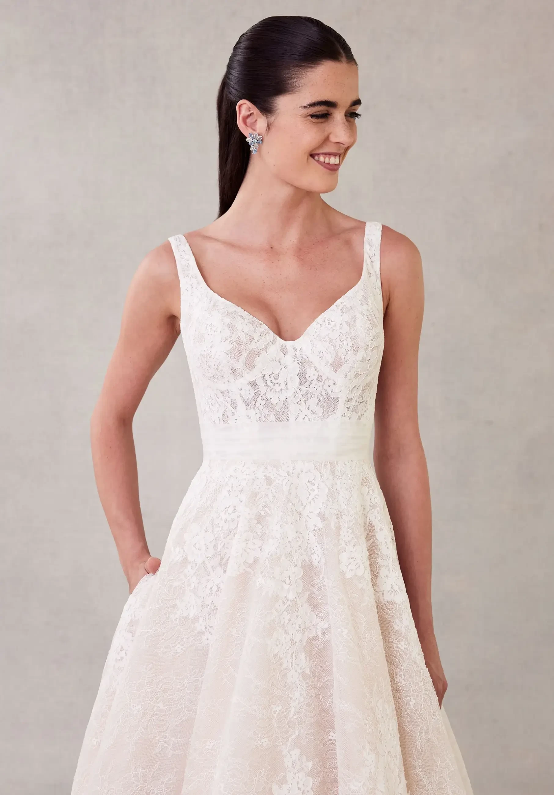 model is wearing a sleeveless a-line lace bridal gown