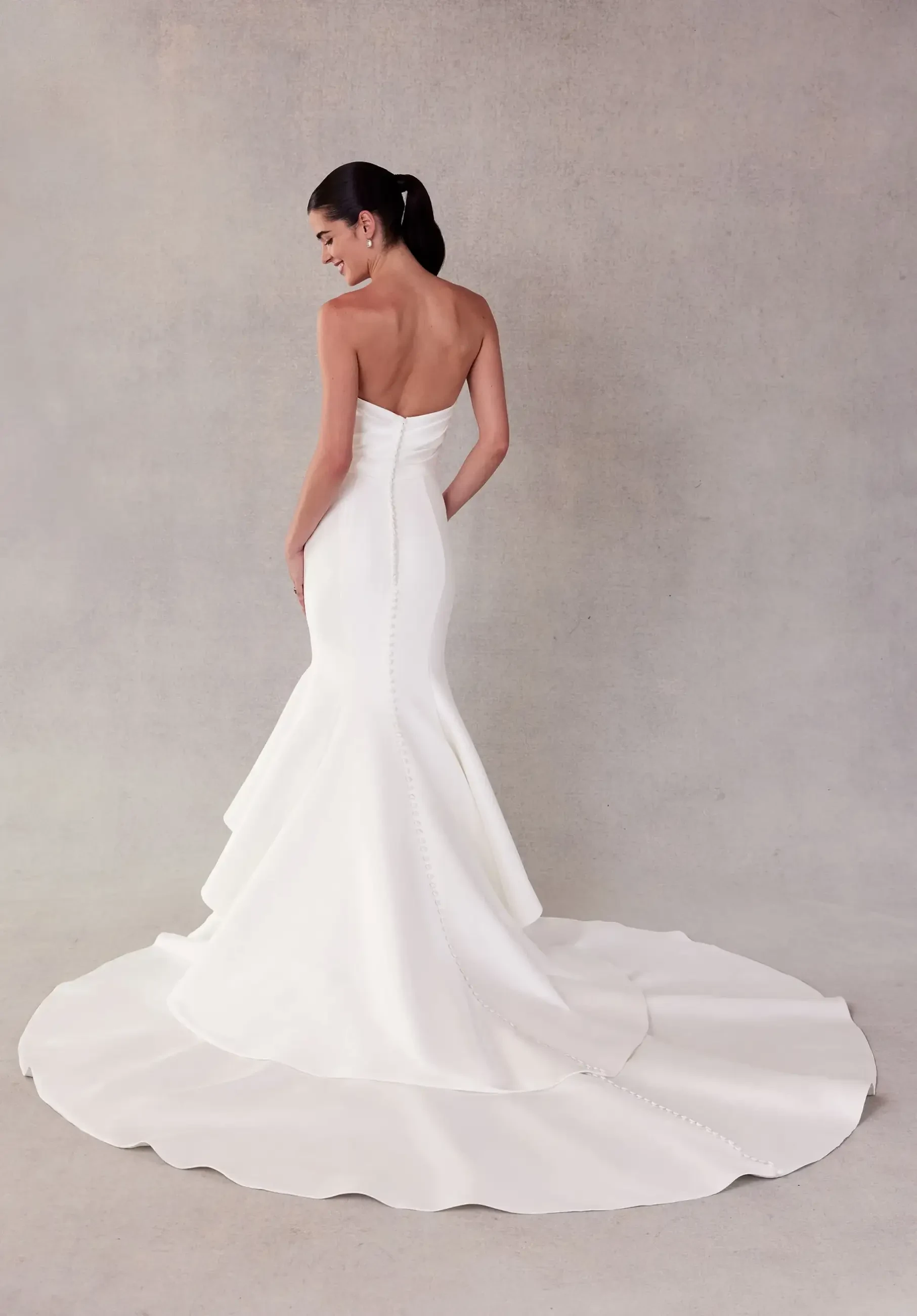 model is wearing a strapless minimalist mermaid wedding dress