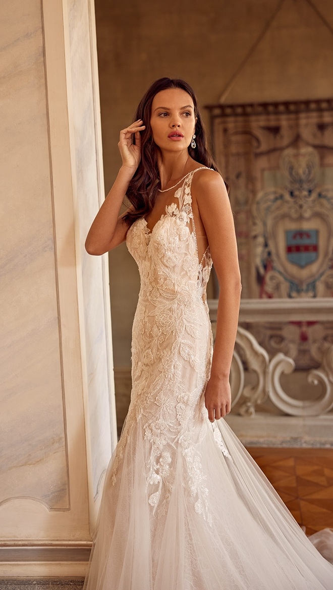Model wearing a bridal gown and posing near the wall