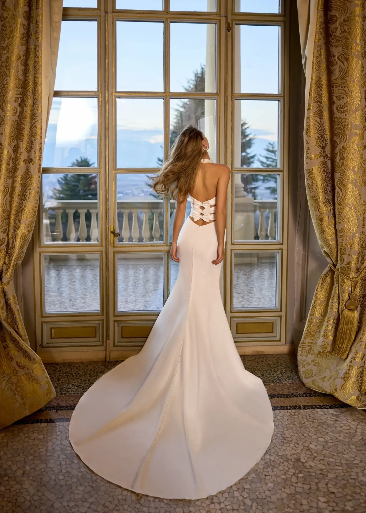 model is wearing a sleek sleeveless wedding dress