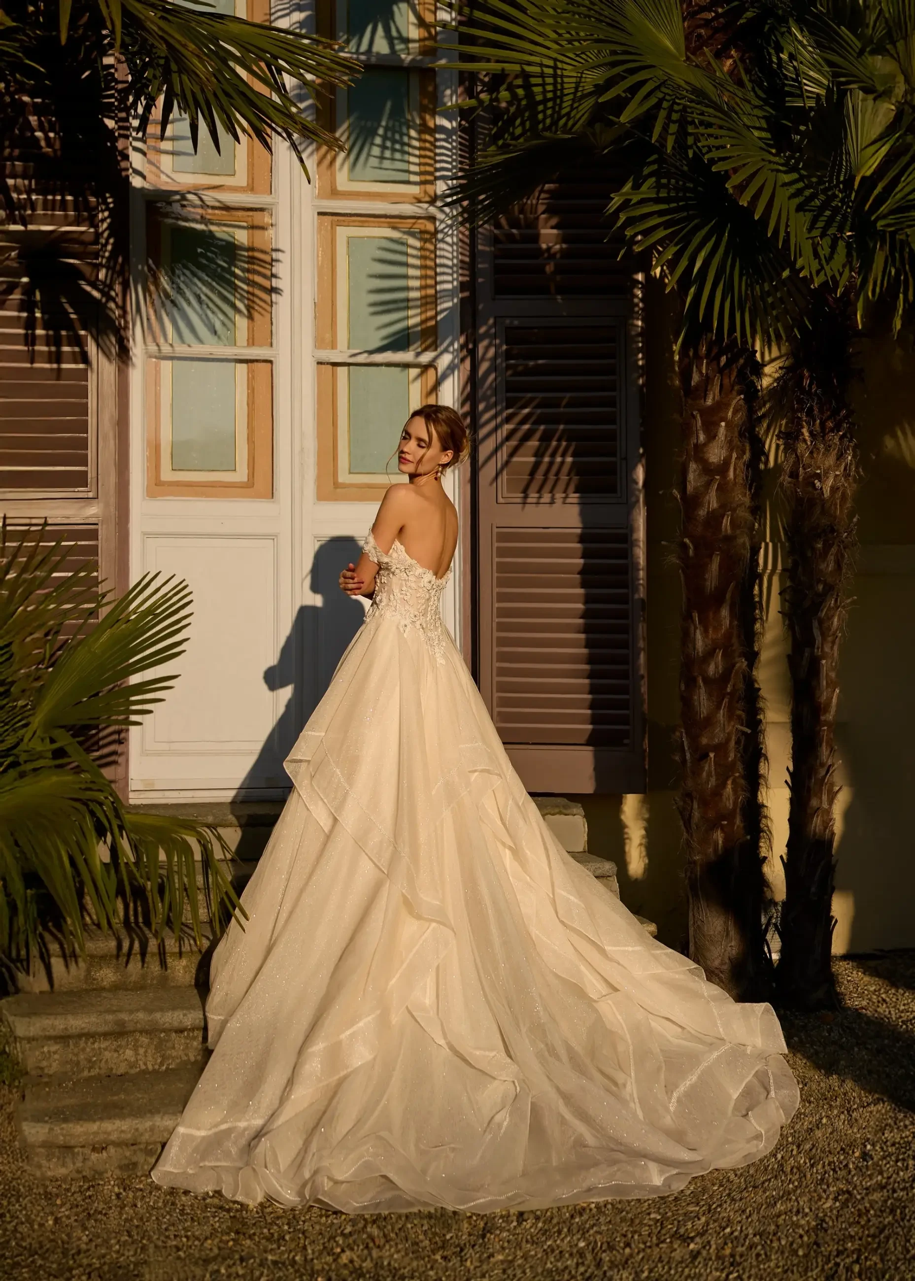 model wears an off the shoulder ball gown wedding dress