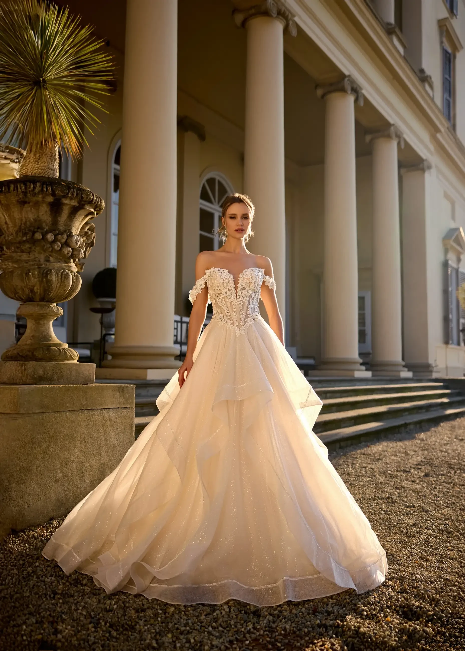 model wears an off the shoulder ball gown wedding dress